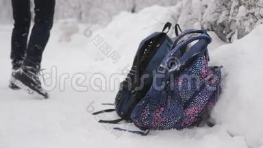 特写四个背包在雪地里走在最前面，女孩们在雪地上奔跑，在他的背包里抓背包